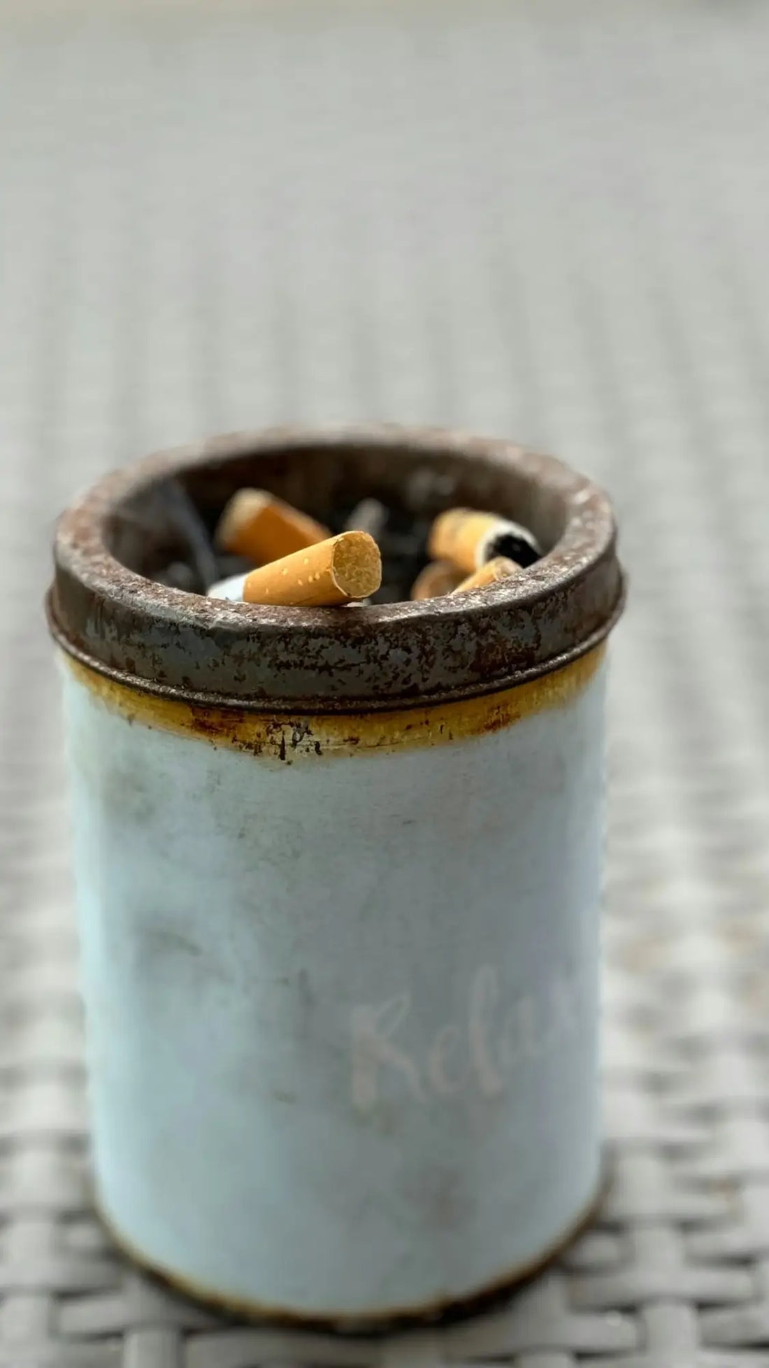 a white cup filled with cigarettes on top of a table