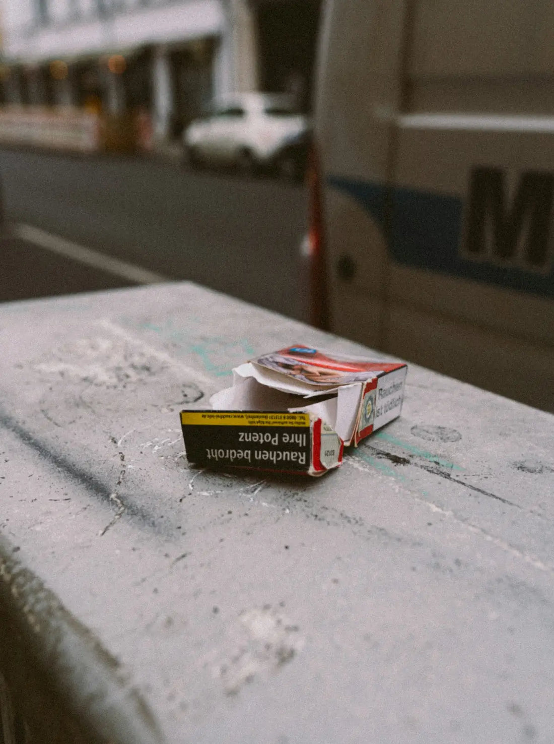 Ett öppet cigarettpaket, mestadels rött och vitt, med en svart och gul varningsetikett.