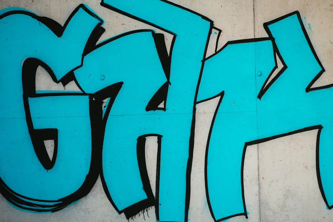 Ljusblå graffiti med svarta konturer på en betongvägg