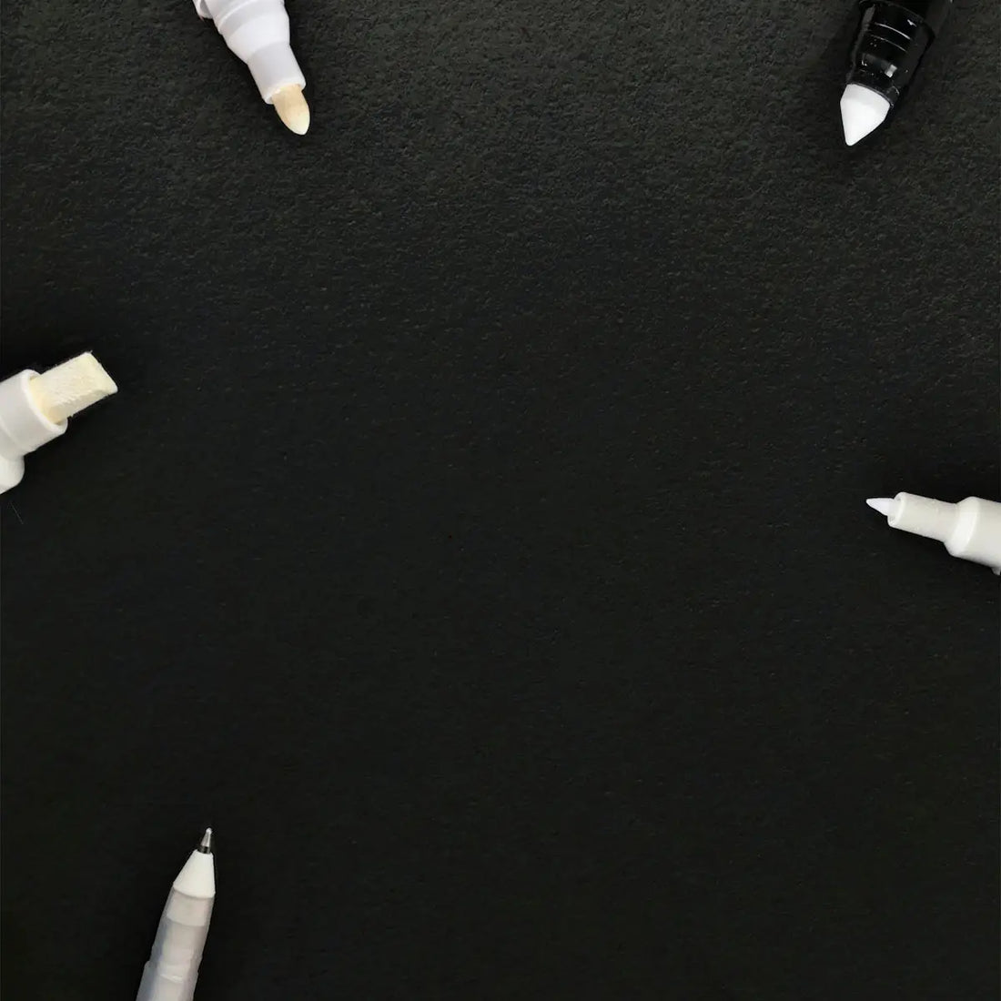 Vit markeringspenna med svart kapsel och spets, glansig finish.