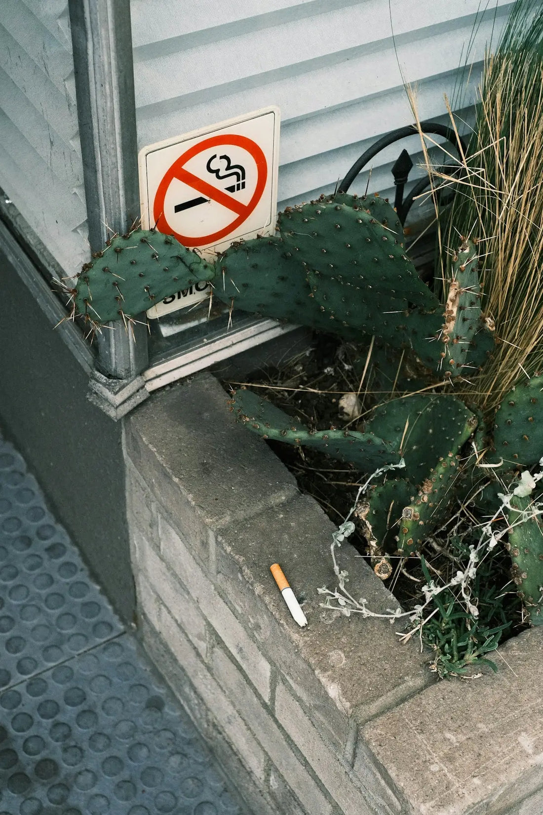 En cigarett som vilar på en tegelstenskant.