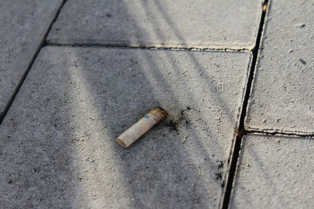 En använd, ljus cigarettfimp med ett fläckigt filter.