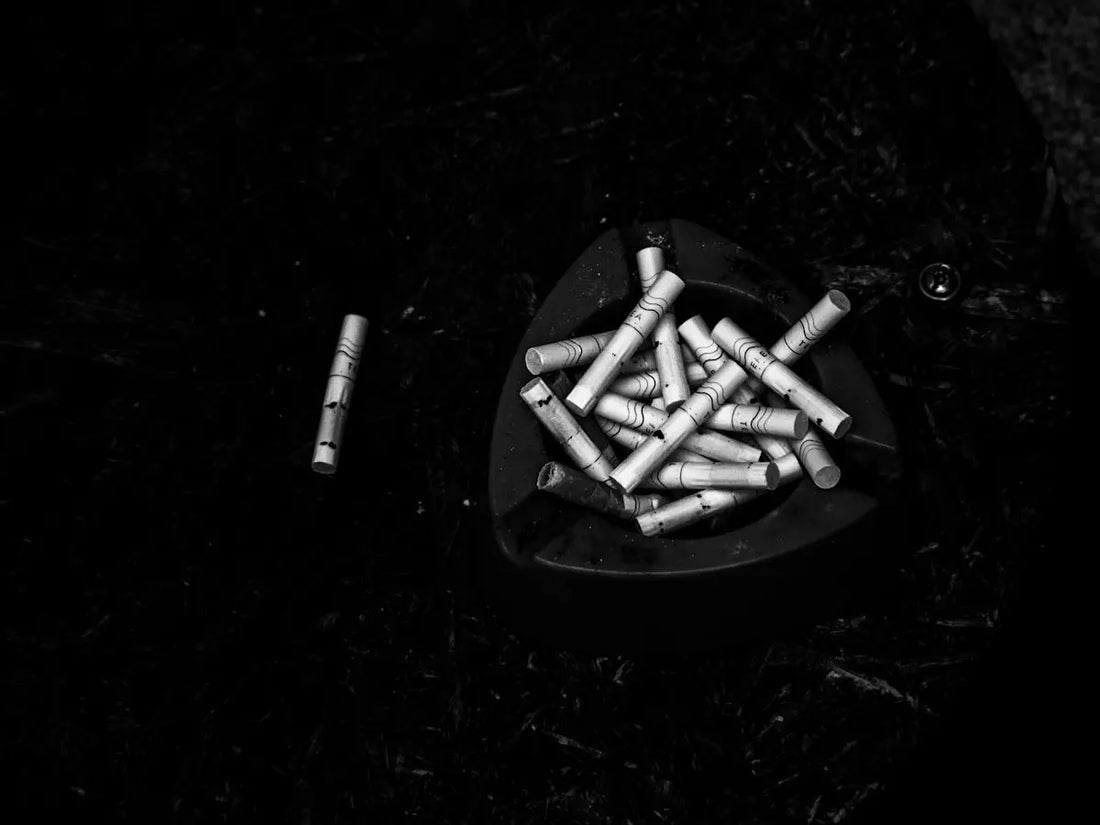 Askfat med cigarettrök och en enda cigarett.