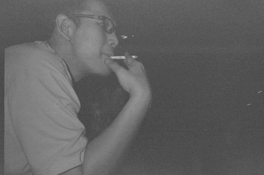 A man smoking a cigarette in a black and white photo