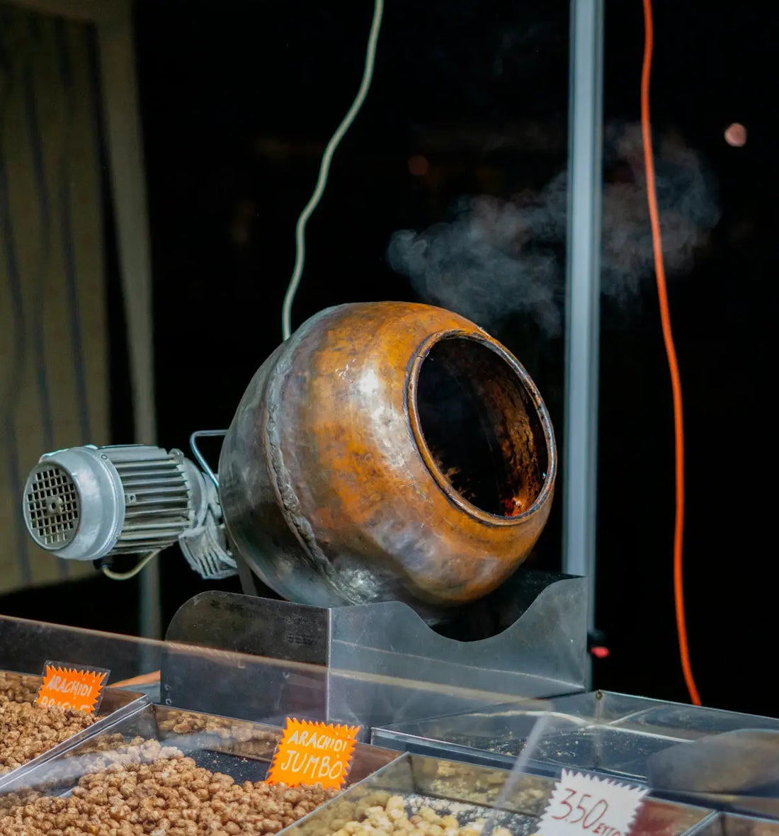 Keramisk lerkruka med rök som stiger upp, rustika bruna och svarta nyanser, troligtvis använd för rostning eller matlagning.